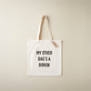 White tote bag with text 'My other bag's a Birkin' on a beige background