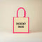 Jute bag with pink frame and handles labeled 'Emergency Snacks' on a beige background