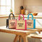 Three 'Emergency Snacks' bags in black, pink, and blue on a kitchen counter.